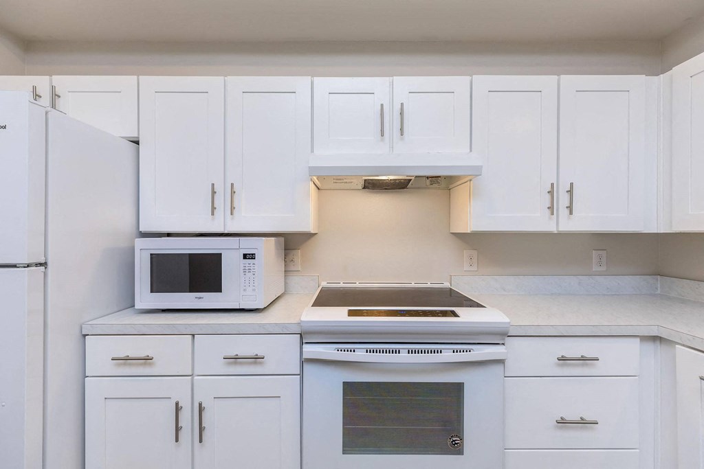 a kitchen with white cabinets and a microwave and a stove at Mariposa at Westchester, Texas, 75052