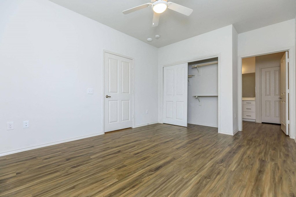 an empty living room with white walls and a ceiling fan at Mariposa at Westchester, Texas
