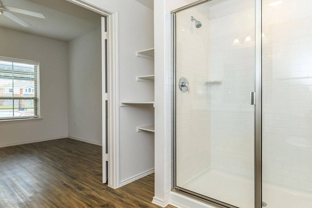 a walk in shower with a glass door in a bathroom at Mariposa at Westchester, Texas, 75052