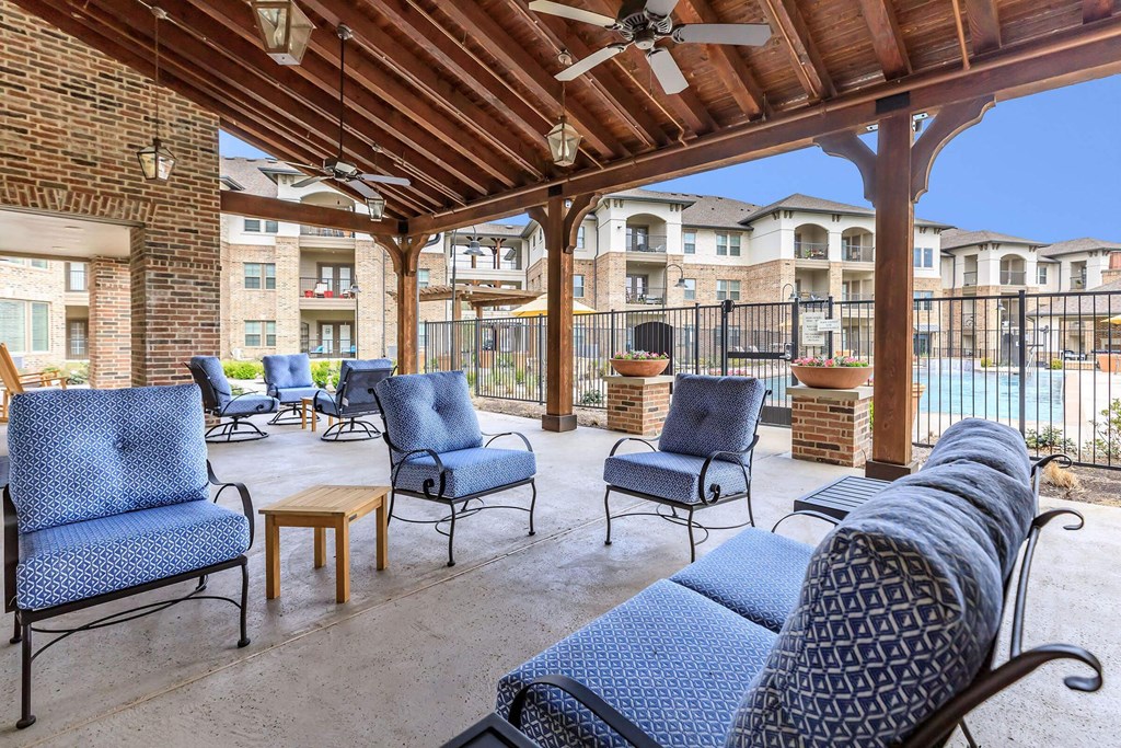 a patio with chairs and a ceiling and a pool at Mariposa at Westchester, Texas, 75052