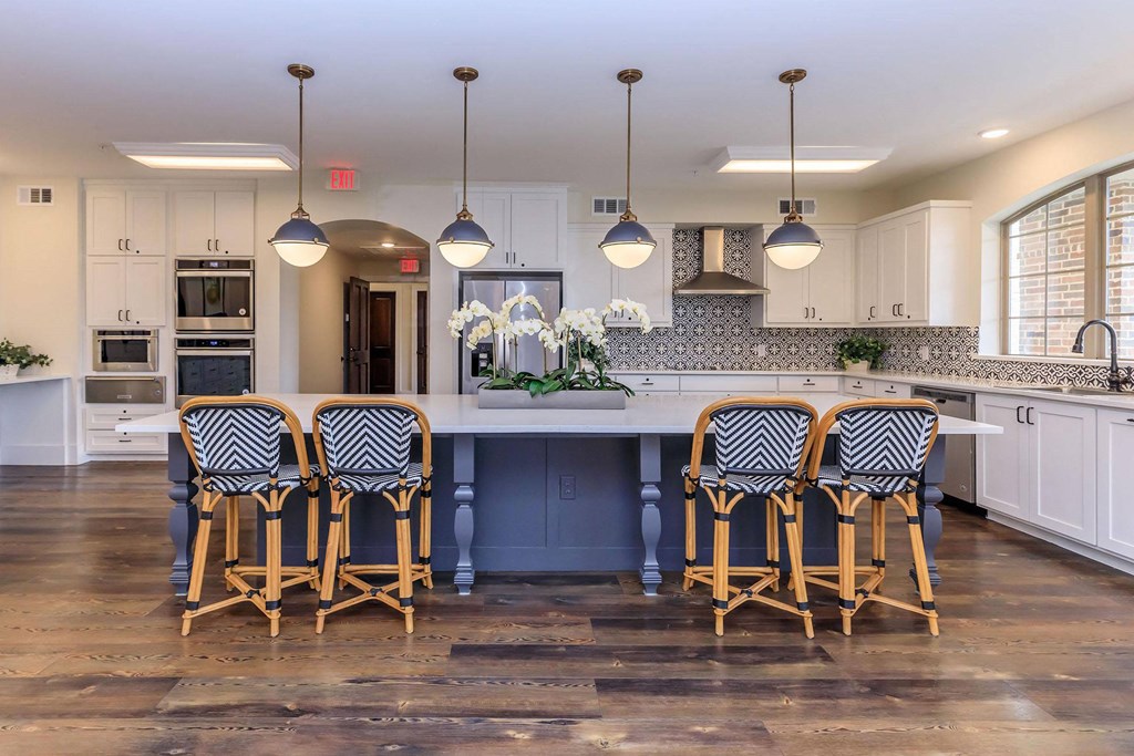 a large kitchen with a large island and chairs at Mariposa at Westchester, Texas