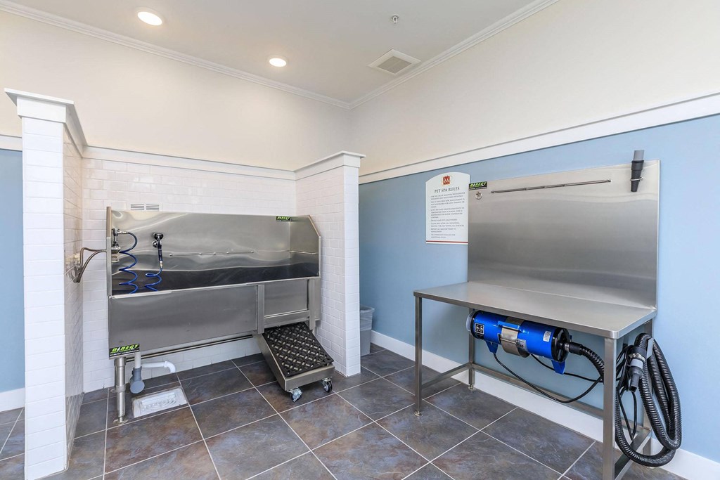 a laundry room with a stainless steel refrigerator and a sink at Mariposa at Westchester, Grand Prairie, TX