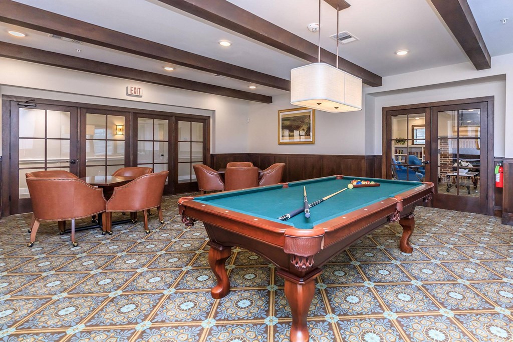 a pool table in a game room with chairs at Mariposa at Westchester, Texas 