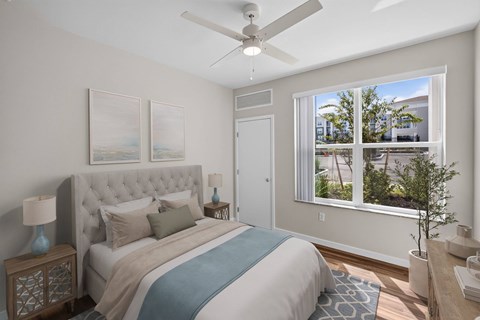 A bedroom with a large bed and a ceiling fan.