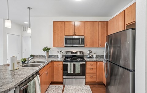 A modern kitchen with wooden cabinets and stainless steel appliances.