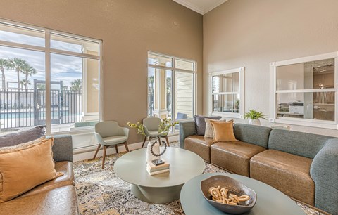 A living room with a couch, chairs, and a coffee table with a bowl of pretzels on it.
