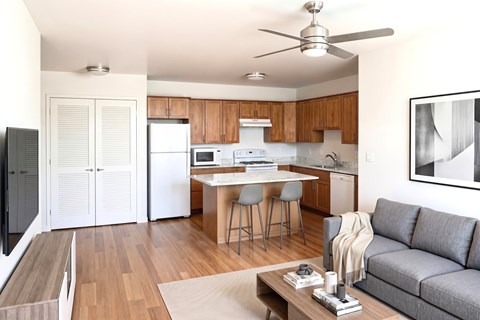 A modern kitchen with a dining table and a grey sofa.