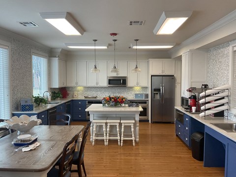 a large kitchen with blue and white cabinets and a table
