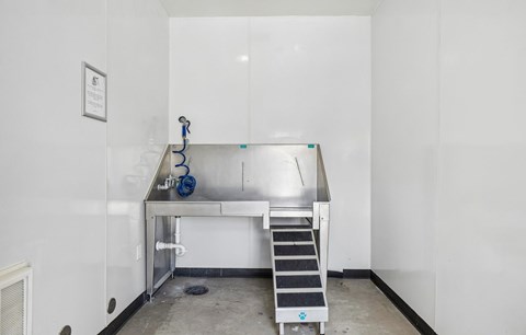 A clean, empty room with a stainless steel table and a metal staircase.