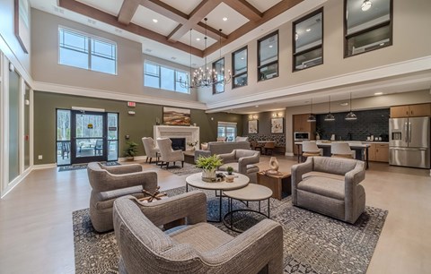 A spacious living room with a large grey sofa set and a coffee table in the center.