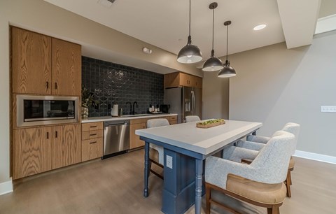A kitchen with a table and chairs.