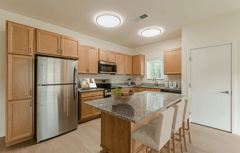 A kitchen with wooden cabinets and a granite countertop.