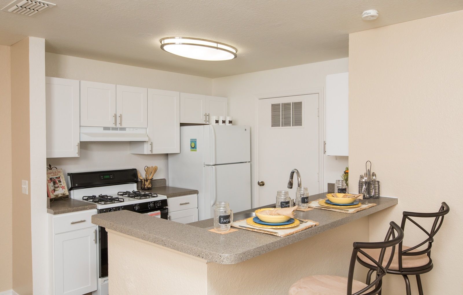 A kitchen with a table set for two.