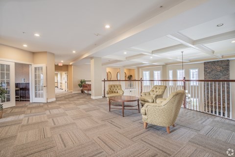 A spacious living room with a patterned carpet and a sofa.