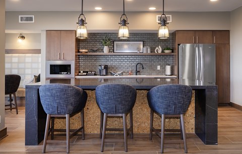 A kitchen with a bar area featuring a counter and chairs.