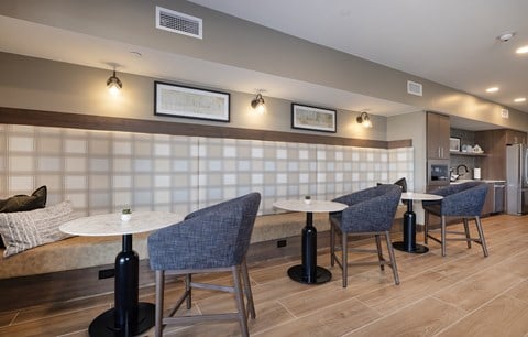 A modern dining area with a white table and blue chairs.