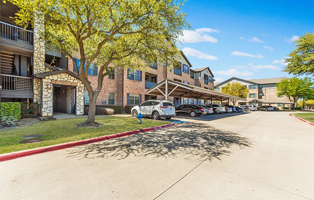 Dominium_The Cesera 55+ Apartments_Exterior Apt Building and Covered Carport Parking Space_Garland, TX