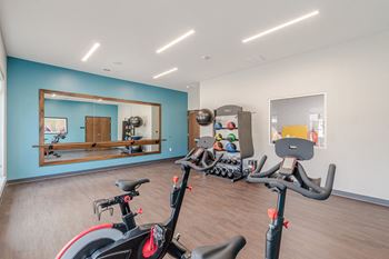 A room with exercise equipment and a mirror on the wall.