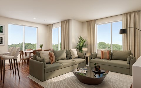 A modern living room with a large window and a view of trees outside.