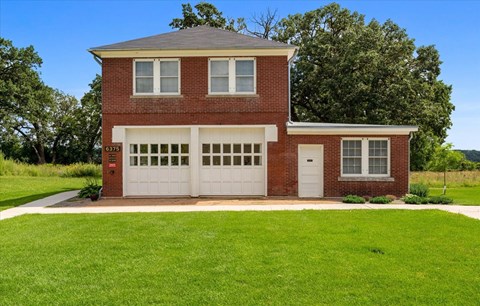A red brick house with a white garage door.