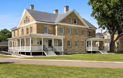 A large brick house with a porch and a covered staircase.