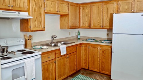 a kitchen with white appliances and wooden cabinets
