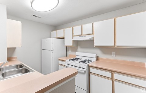 A kitchen with white appliances and cabinets.