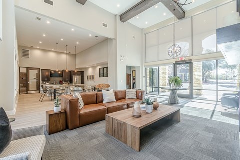 A modern living room with a brown leather couch and a wooden coffee table.