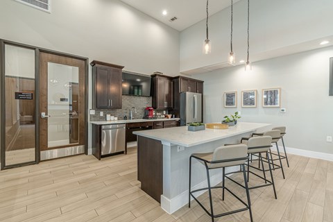 A modern kitchen with a large island and bar stools.