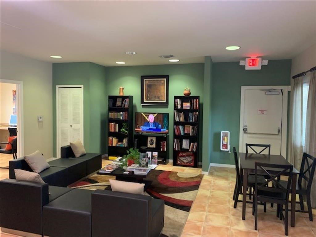 A living room with a couch, a coffee table, and a bookshelf.