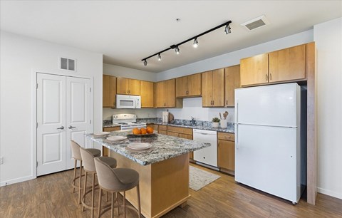 A kitchen with a white refrigerator and wooden cabinets.