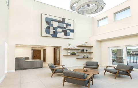 A modern living room with a large abstract painting on the wall and a variety of seating options.