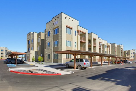 A parking lot in front of a multi-story building.