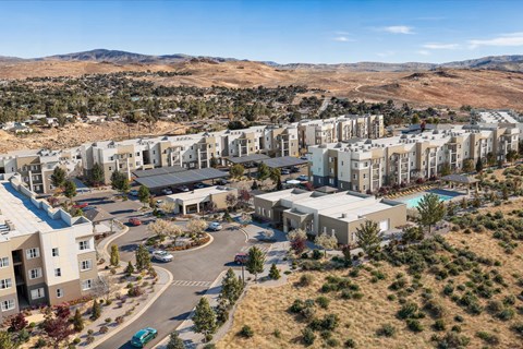 A large residential complex with a swimming pool and a parking lot.