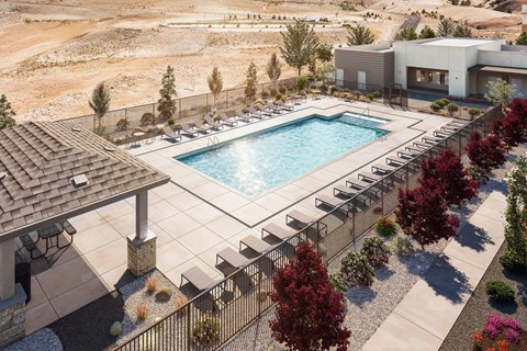 A pool surrounded by trees and a building in the background.