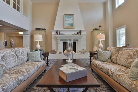 a living room with couches a table and a fireplace