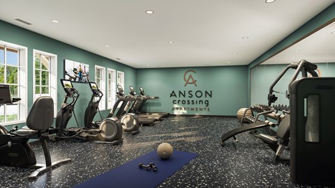 A fitness room with a blue mat and a sign that says "ANSON CROSSING".