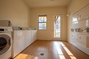 an empty kitchen with white appliances and wood floors