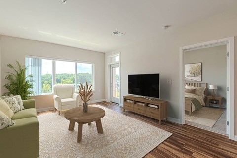 A living room with a green couch, a wooden coffee table, and a flat screen TV.