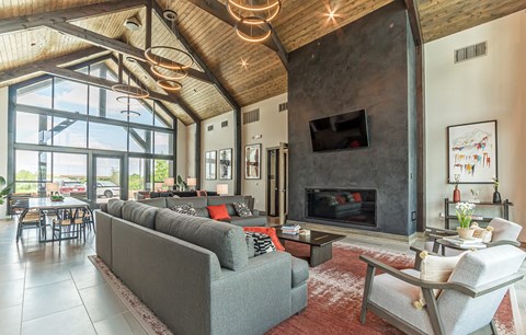 A modern living room with a grey couch and a fireplace.
