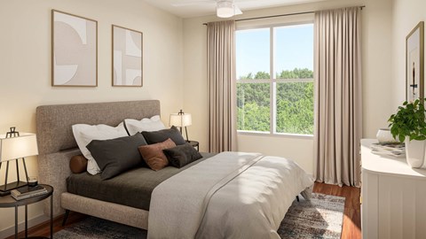 A bedroom with a large bed and a view of trees outside the window.