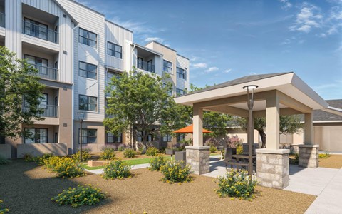 A modern apartment complex with a gazebo-like structure in the front yard at Orchard Springs 55+ Apartment , Surprise