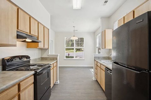 A kitchen with black appliances and wooden cabinets.