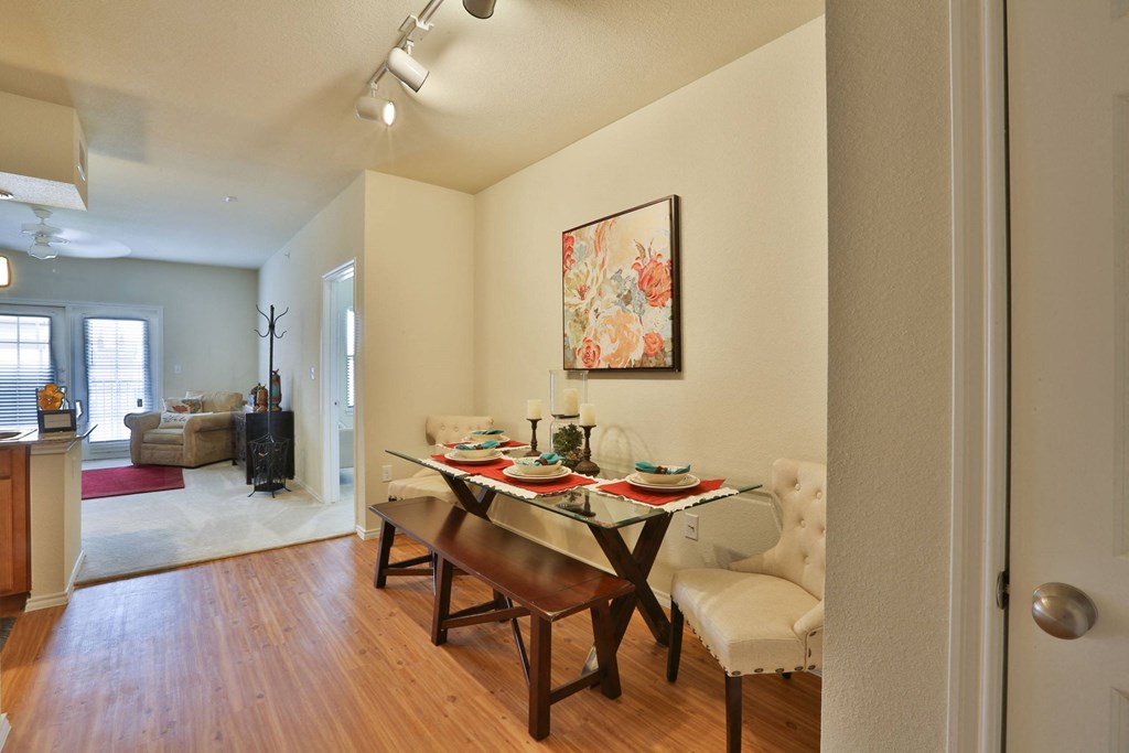 a dining room with a table and chairs and a living room at Cedars of Elk Drive 55+ Apartments, Burleson, 76028