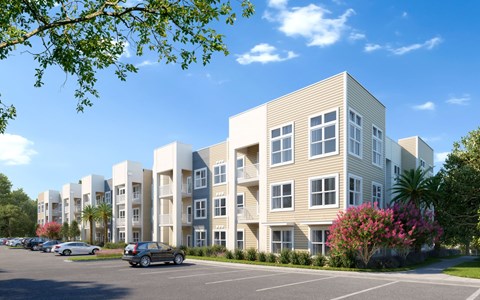A row of modern apartment buildings with cars parked in front at The Mira Apartments, Apopka 32712