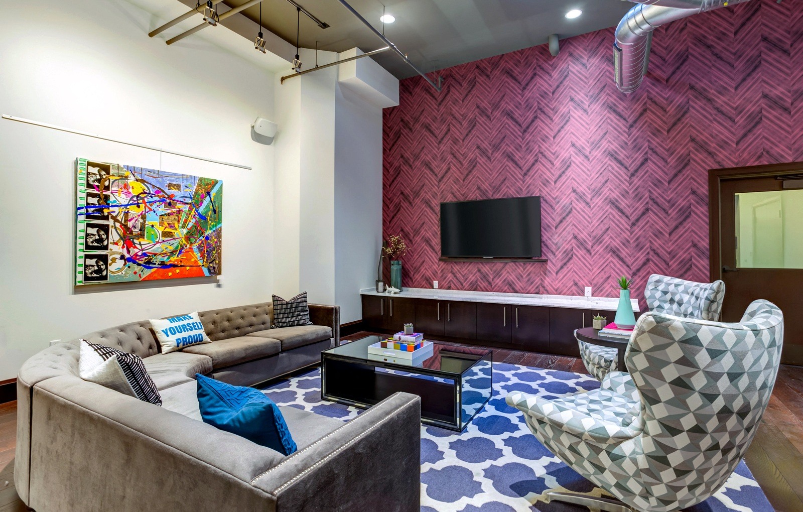 A living room with a grey couch and a patterned chair.