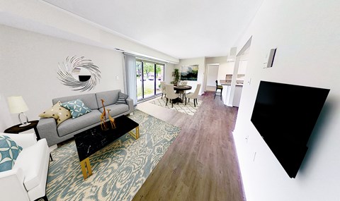 A living room with a grey couch and a black coffee table.