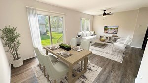 A dining room with a table set for two and a potted plant on the side table.