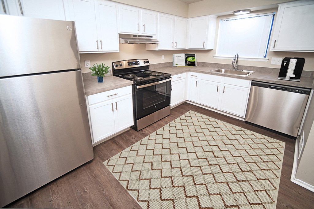 Uptown 11 upgraded kitchen with window, stainless steel appliances, modern white cabinetry