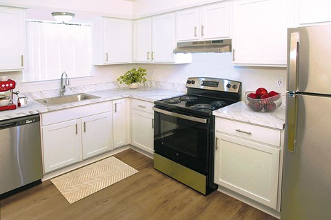 A kitchen with white cabinets and a black stove top oven.